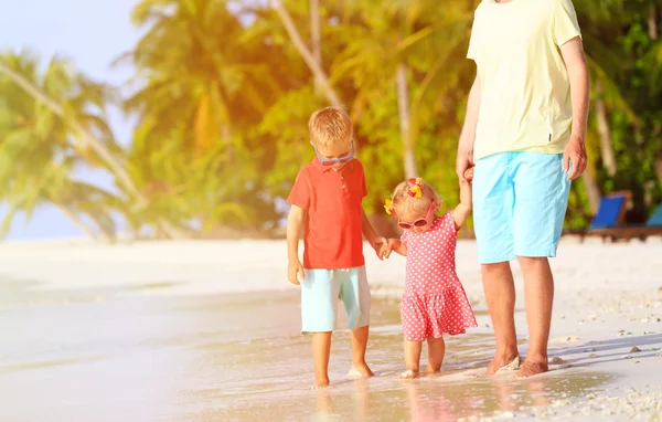 Vader en twee kinderen walking op zomer strand — Stockfoto