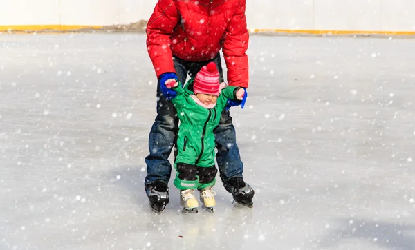 Отец и ребенок учатся кататься на коньках зимой — стоковое фото