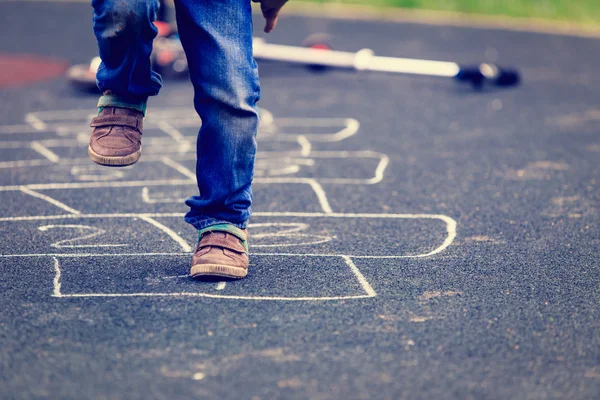 Criança jogando hopscotch no playground ao ar livre — Fotografia de Stock