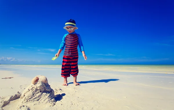 Mały chłopiec budujący zamek z piasku na tropikalnej plaży — Zdjęcie stockowe