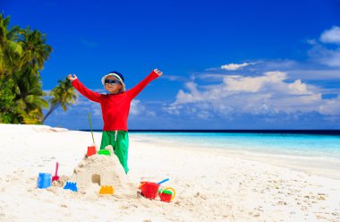 Sahilde inşa sandcastle ile mutlu küçük çocuk