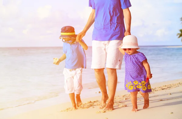 Vader en twee kinderen lopen op tropisch strand — Stockfoto