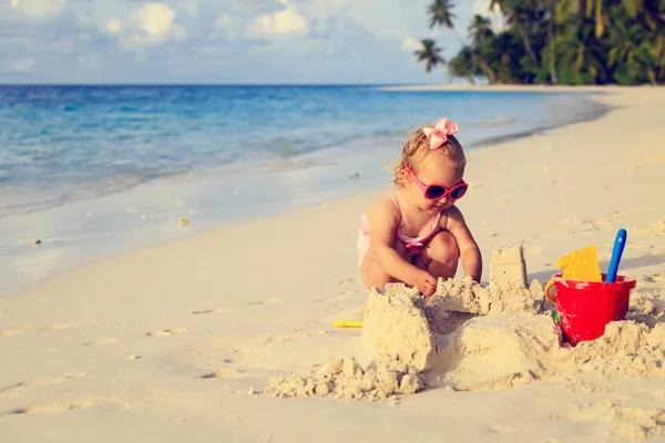 Carino bambina che gioca con la sabbia sulla spiaggia — Foto Stock