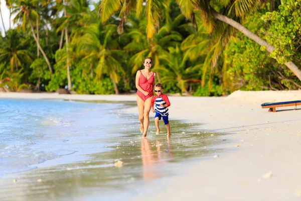Moeder en zoon lopen in water op strand — Stockfoto