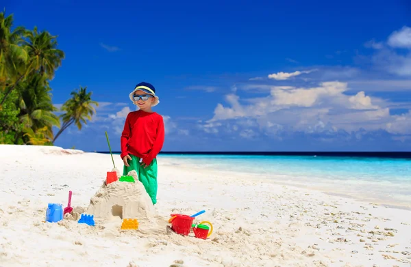 Niño pequeño edificio castillo de arena en la playa tropical —  Fotos de Stock