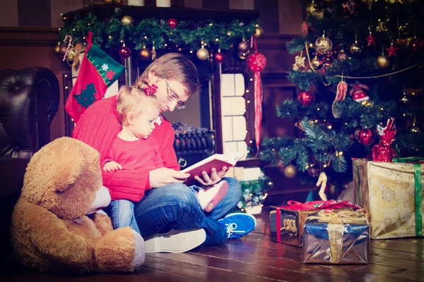 Πατέρας και κόρη ανάγνωση το βιβλιαράκι τα Χριστούγεννα — Φωτογραφία Αρχείου
