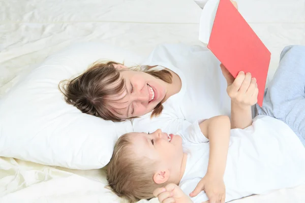 Mor och Son läsa bok i sängen — Stockfoto