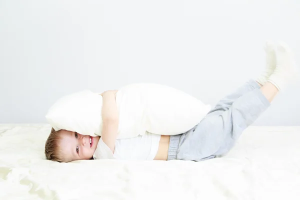 Små barn leker i sängen — Stockfoto