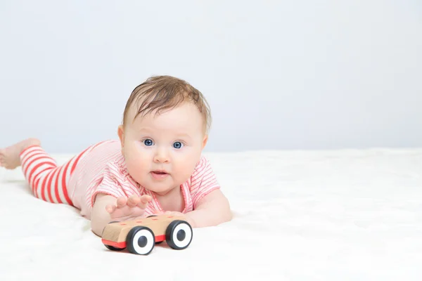 Söt liten flicka att nå bil leksak — Stockfoto