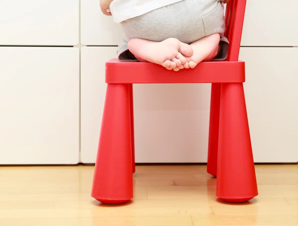 Child feet on baby chair, kids home safety concept — Stock Photo, Image