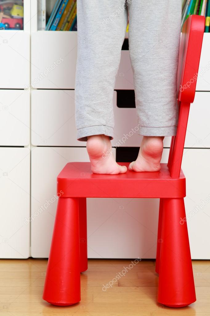 child feet on baby chair, kids home safety concept