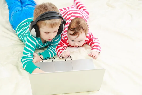 Little brother and sister with laptop at home — Stock Photo, Image