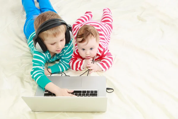 Little brother and sister with laptop at home — Stock Photo, Image