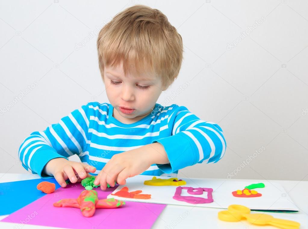 little boy playing with clay dough