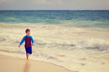 mutlu küçük çocuk kum plajı üzerinde çalışan