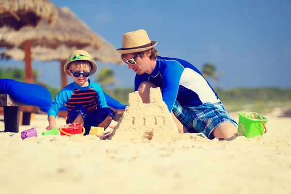 Padre e hijo construyendo castillo de arena en la playa — Foto de Stock