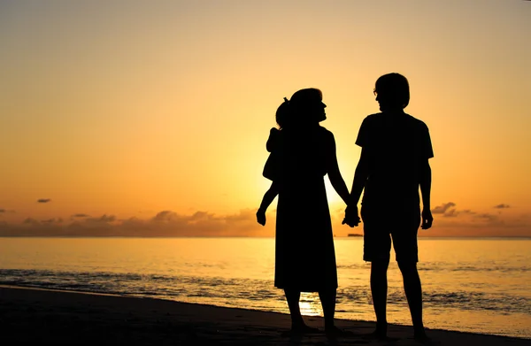 Casal romântico com criança pequena na praia tropical por do sol — Fotografia de Stock