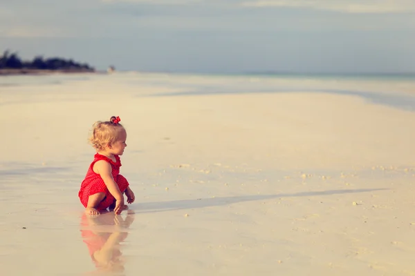 Симпатичная девочка, играющая на летнем пляже — стоковое фото