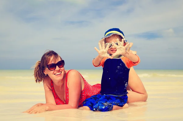 Anya és fia birtoklás móka-val víz strandon — Stock Fotó