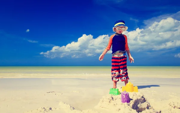 Mały chłopiec budujący zamek z piasku na tropikalnej plaży — Zdjęcie stockowe