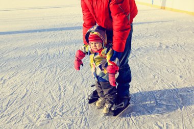 Baba ve çocuk kışın paten için öğrenme