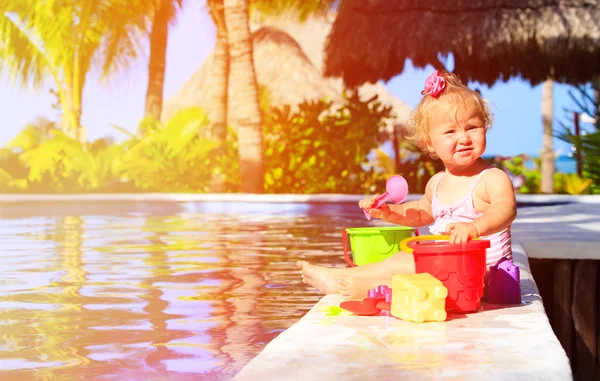 Linda niña jugando en la piscina en la playa — Foto de Stock