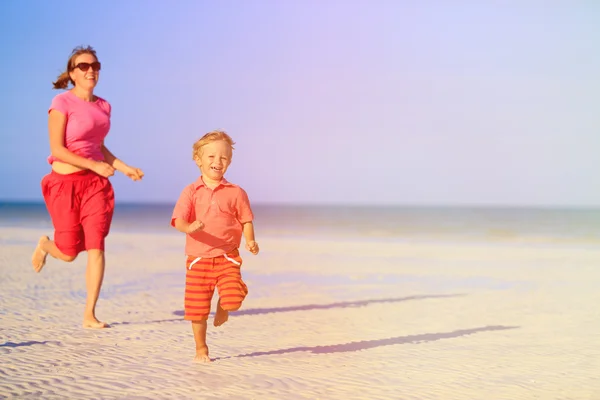 Heureux petit garçon avec mère courir sur la plage — Photo