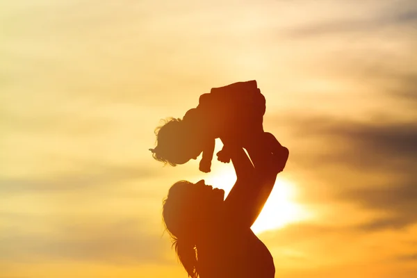 Moeder en kleine dochter spelen bij zonsondergang — Stockfoto