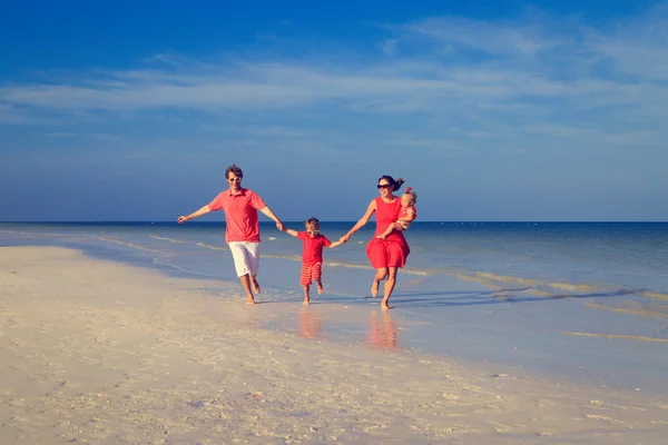 Gezin met twee kinderen plezier op tropisch strand — Stockfoto