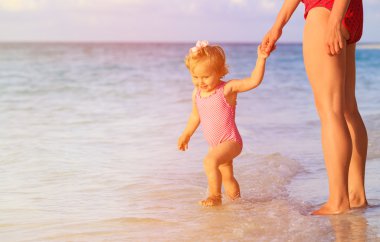 Anne ve küçük kızı sahilde yürüyor.