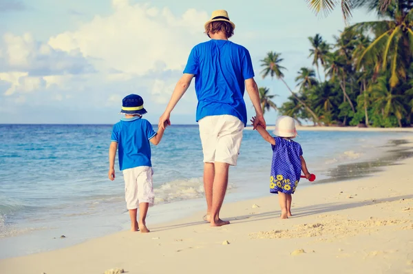 Père et deux enfants marchant sur la plage d'été — Photo