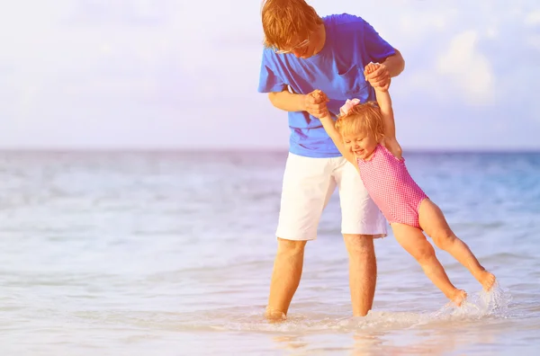 Otec a malá dcera baví na pláži — Stock fotografie