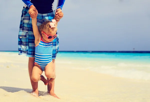 Padre celebración lindo poco hija en playa — Foto de Stock