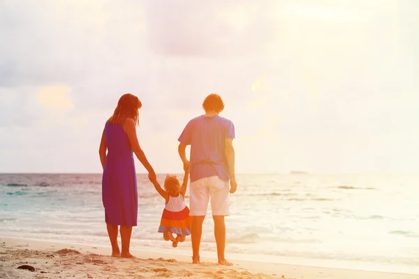 Familia feliz con el niño divirtiéndose en la playa puesta del sol —  Fotos de Stock