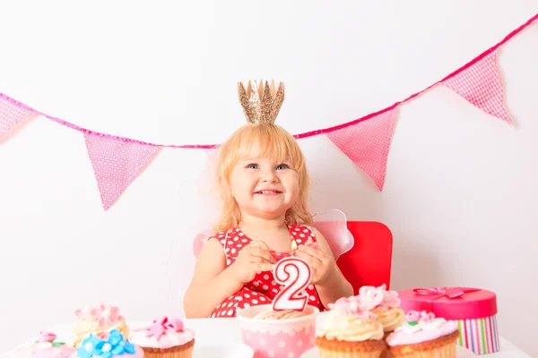 Menina bonito com doces na festa de aniversário — Fotografia de Stock