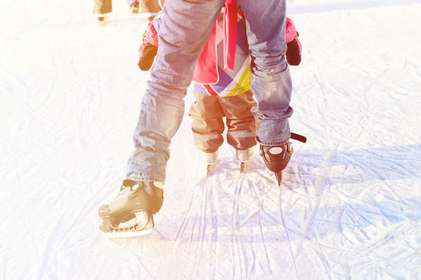 Padre e hija pequeña pies aprender a patinar en invierno —  Fotos de Stock