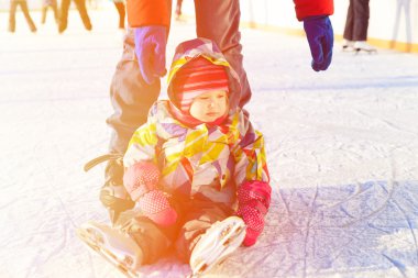 Baba ve küçük kızı kışın paten için öğrenme