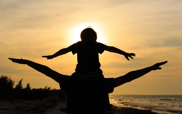 Père et fils jouent sur la plage du coucher du soleil — Photo