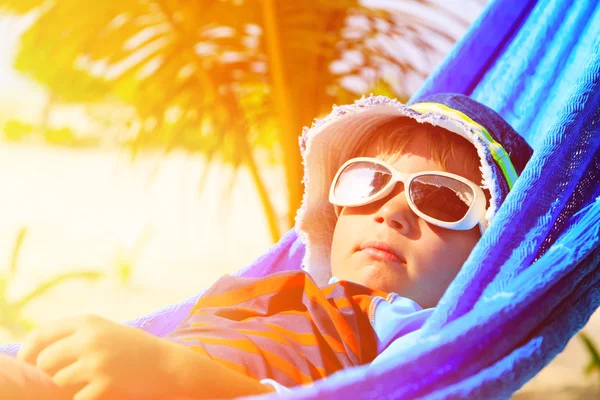 Menino feliz relaxado em rede na praia — Fotografia de Stock