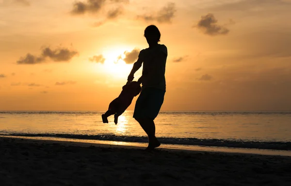 Père et petite fille jouent aux silhouettes au coucher du soleil — Photo