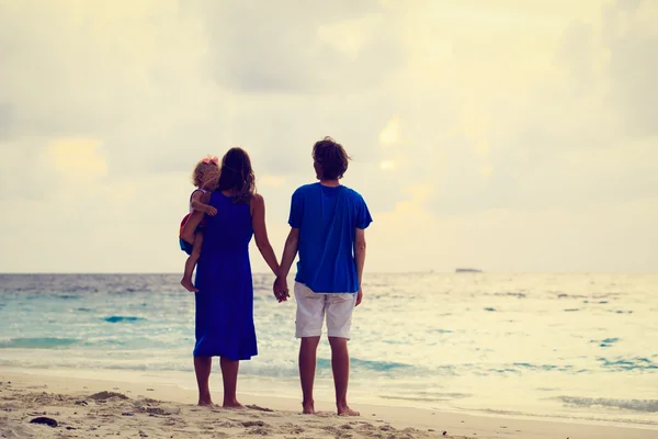 Romantyczna para z małym dzieckiem w sunset beach — Zdjęcie stockowe
