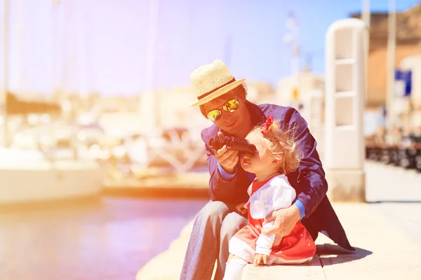 Vader en dochtertje kijken naar verrekijkers in de haven — Stockfoto