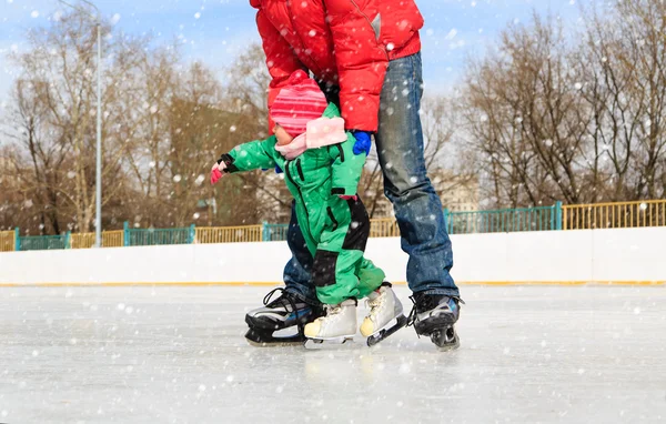 Baba ve küçük kızı kışın paten için öğrenme