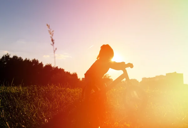 Petite fille à vélo au coucher du soleil, enfants actifs — Photo