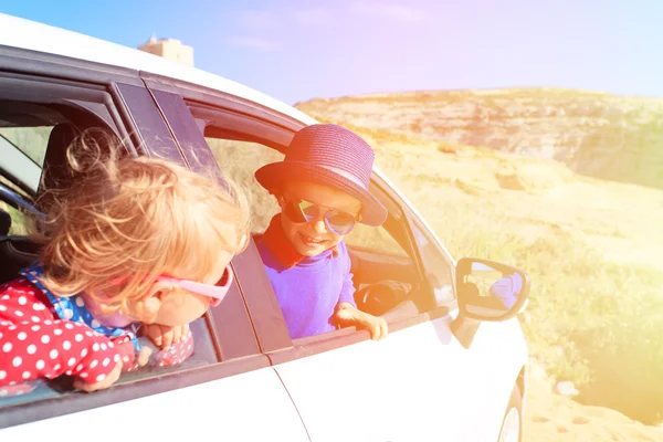 Ładny mały chłopiec i dziewczynka podróż samochodem w górach — Zdjęcie stockowe