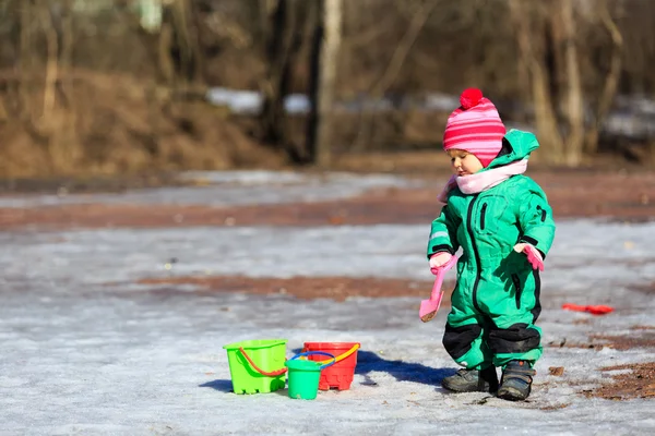 Маленькая девочка зимой копает снег — стоковое фото