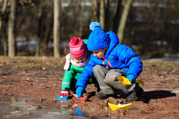 Мальчик и девочка играют с водой весной — стоковое фото