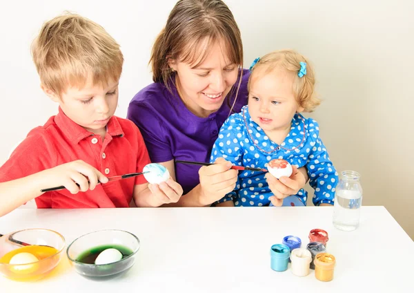 Mère avec des enfants peignant des œufs pour Pâques — Photo