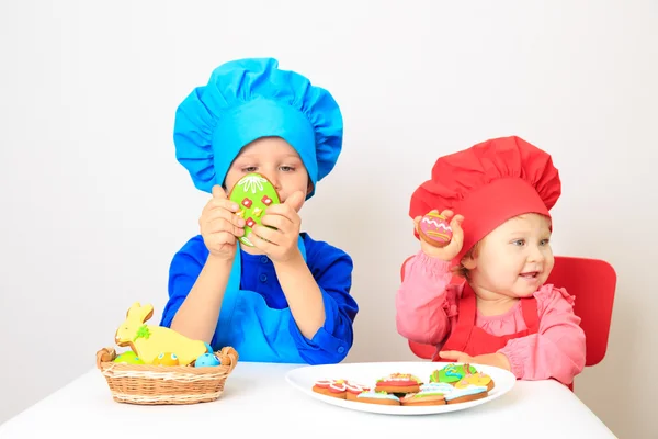Sevimli küçük kız ve erkek Paskalya kurabiyeleri ile oynama — Stok fotoğraf
