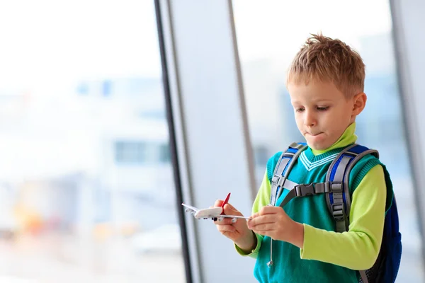 Liten pojke leker med leksak plan på flygplatsen — Stockfoto
